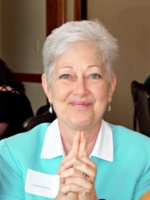 Barb has white colored hair, and blue eyes. Barb is smiling. Barb is wearing a blue shirt with white color and white name tag. Barb is clasping her hands together for this photo. Barb Smith is a Board Member at Large. Barb works as Chief Division of Community Partnerships in the Cecil County Department of Community Services. Barb enjoys helping in her community wherever possible, has a love of cats, and all animals. She loves to play pickle ball, and she is a member of the Drug Free Cecil Coalition. 