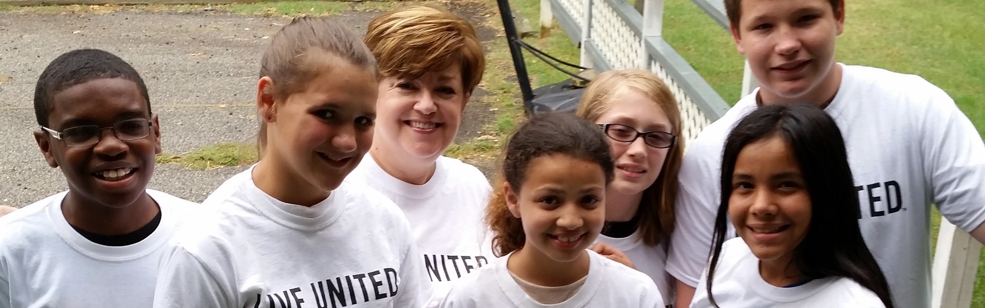 7 people with photo with short brown hair, or long brown hair, red hair, and blue eyes, with glasses, wearing white t-shirt with black lettering that says Live United.